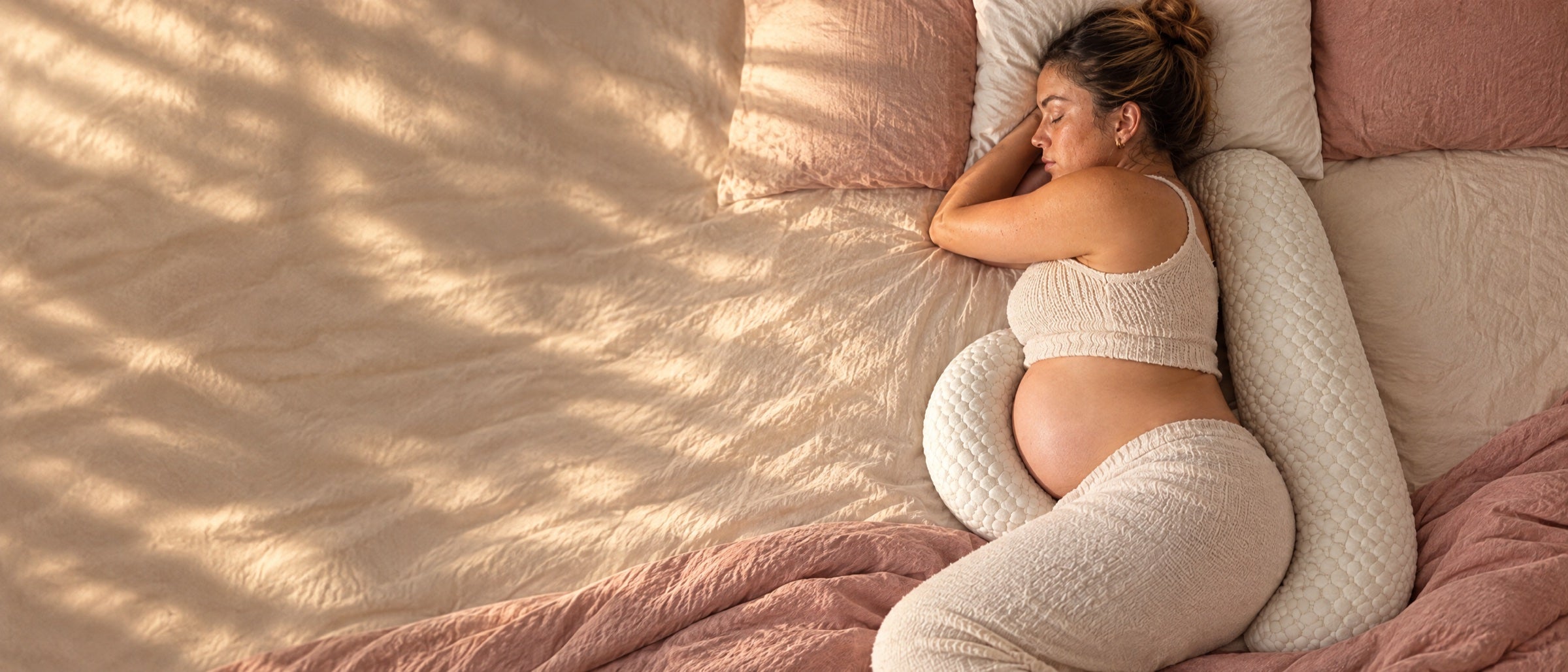 Mama w ciąży śpiąca na boku z poduszką Otuliva
